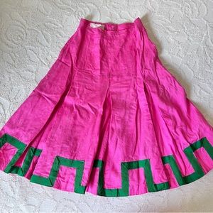 Vintage 1960s Barbie pink linen pleated skirt with green trim around the hem.
